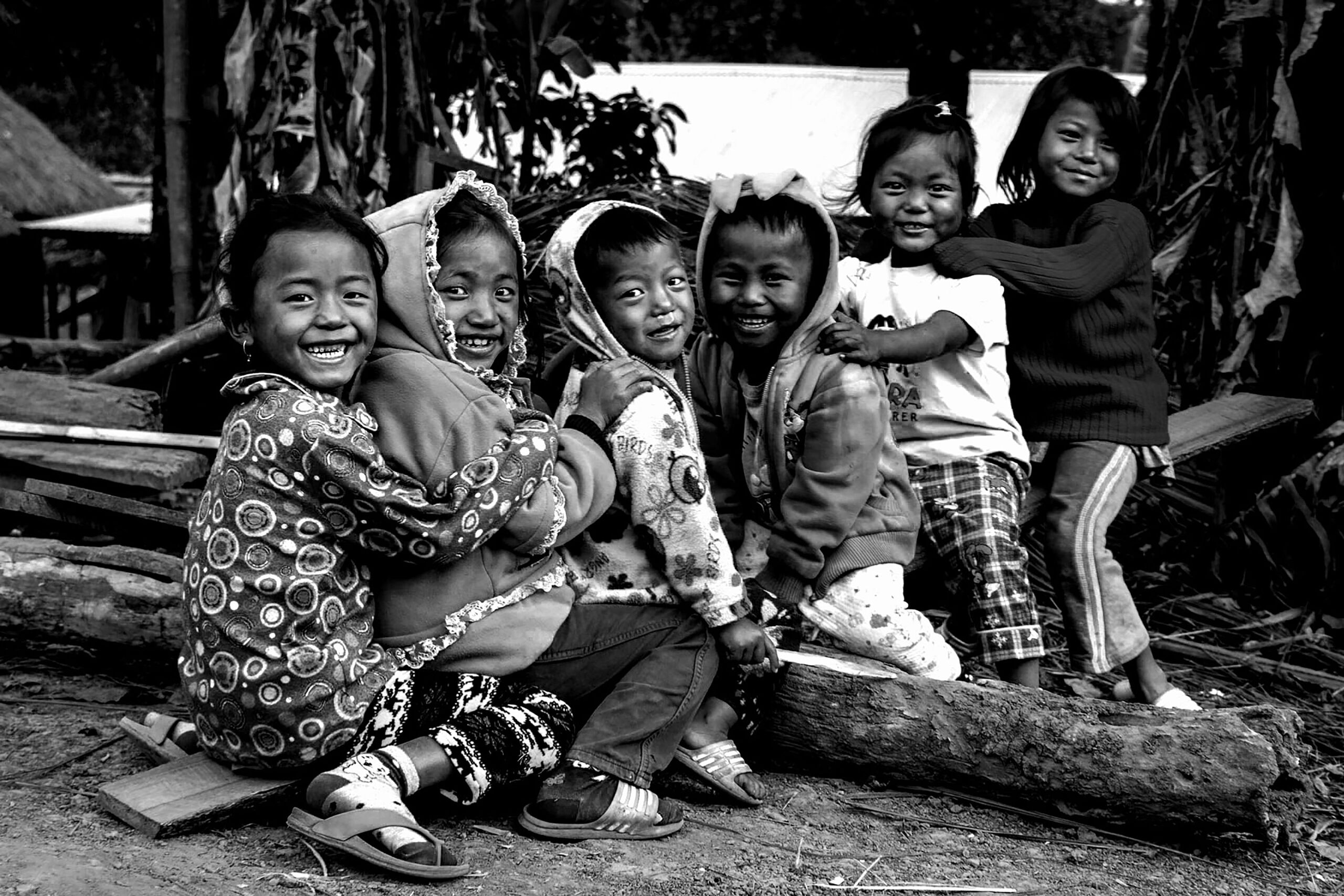 Children of a Pacific island community laughing together, in black and white